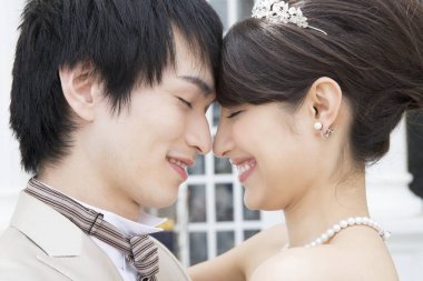 Genç ve güzel Asyalı bir çiftin kucaklaşmasının portresi.