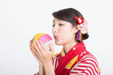 Güzel Asyalı kadın topa üflüyor, yakın görüş