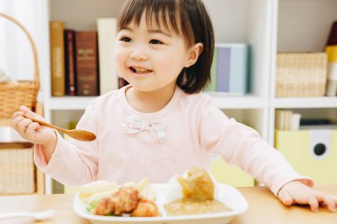 Güzel Asyalı kız evde Japon yemeği yiyor.
