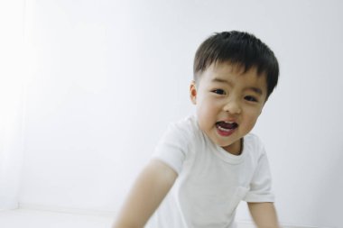 Evde gülümseyen sevimli bir erkek bebek. 