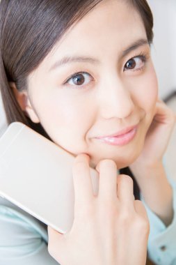 Akıllı telefon tutan genç bir kadın.