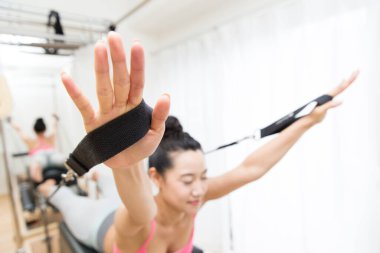 Spor giyinen Japon kadın iç mekanda antrenman yapıyor.