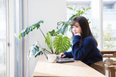 Kafede dizüstü bilgisayar kullanan güzel genç kadın