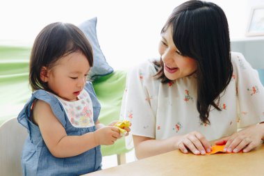 Anne ve kızı evde oynuyorlar.