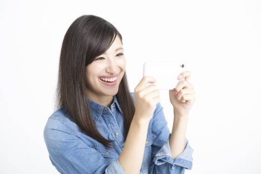 Genç Asyalı kadın akıllı telefonuyla fotoğraf çekiyor. 