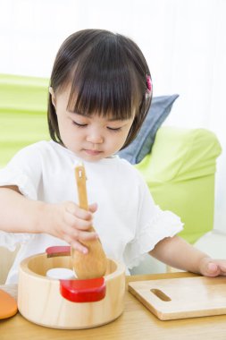 Evdeki oturma odasında oynayan küçük tatlı bir Japon kız.