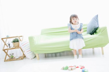 Evdeki oturma odasında oynayan tatlı Asyalı küçük kız.