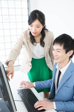 Genç Asyalı kadın ve erkek ofiste çalışıyor.