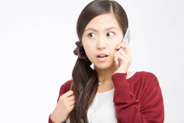 Genç, güzel Asyalı kadın akıllı telefondan konuşuyor. 