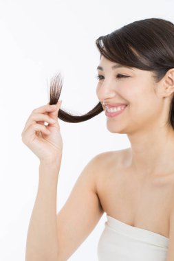  Japon kadın uzun saçlarını tutuyor ve saçlarını ayırıyor. 