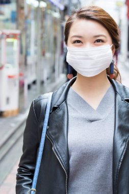 Japonya 'daki tren istasyonunda yüz maskesi takan Asyalı kadın. seyahat ve turizm