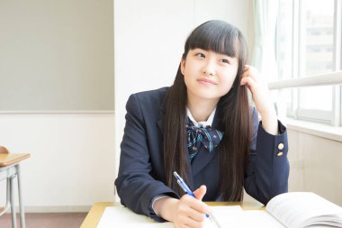 Güzel Japon genç kız sınıfta ders çalışıyor.