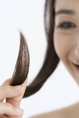  Japon kadın uzun saçlarını tutuyor ve saçlarını ayırıyor. 