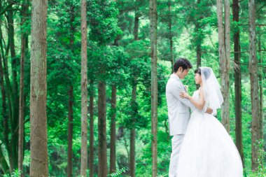 Parkta poz veren Asyalı gelin ve damat 