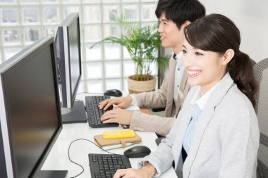 Ofiste çalışan Asyalı kadın ve erkek.