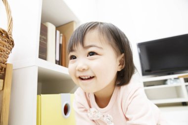 Evde oynayan Asyalı kızın portresi.