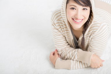 Beyaz arka planda poz veren kapüşonlu Asyalı kadın.