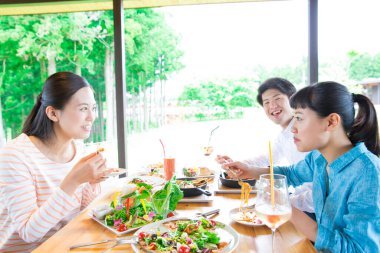 Asyalılar restoranda yemek yiyor. 