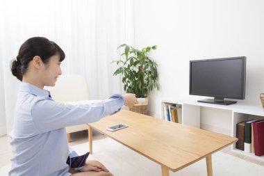 Uzaktan kumandalı Asyalı genç kadın. 