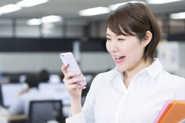 Genç kadın ofiste Smartphone kullanarak