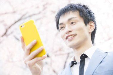 Parkta akıllı telefonu olan genç iş adamının portresi 