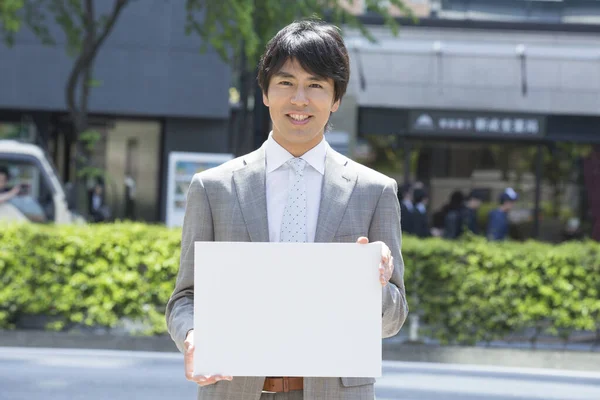 Guapo Profesional Japonés Hombre Negocios Sosteniendo Blanco Cartel Sonriendo Cámara —  Fotos de Stock