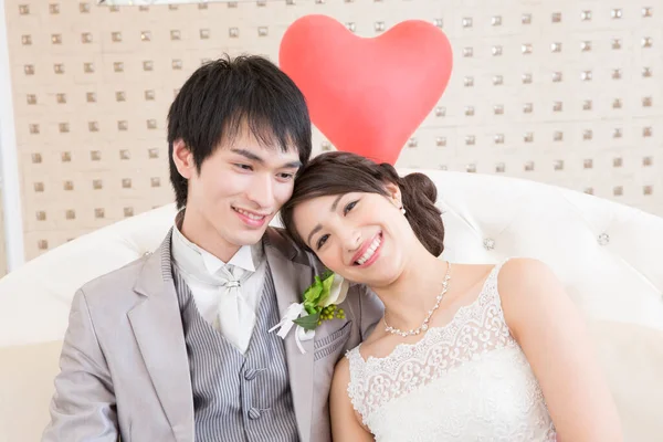 赤い心とポーズする美しい幸せな若い結婚式のカップル — ストック写真