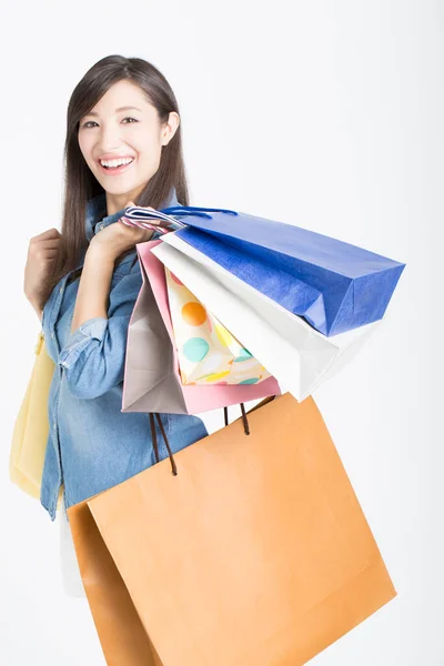 漂亮的笑着的日本女人 提着购物袋 看着白色背景的相机 — 图库照片