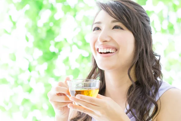 Bahçede çay içen genç bir kadın