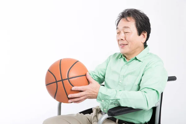 senior man with basketball in Wheelchair  isolated on white background