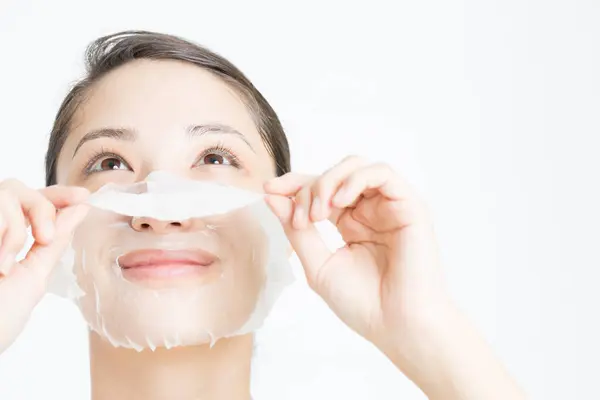 Mujer Asiática Joven Quitándose Máscara Sábana Blanca Concepto Cuidado Piel — Foto de Stock
