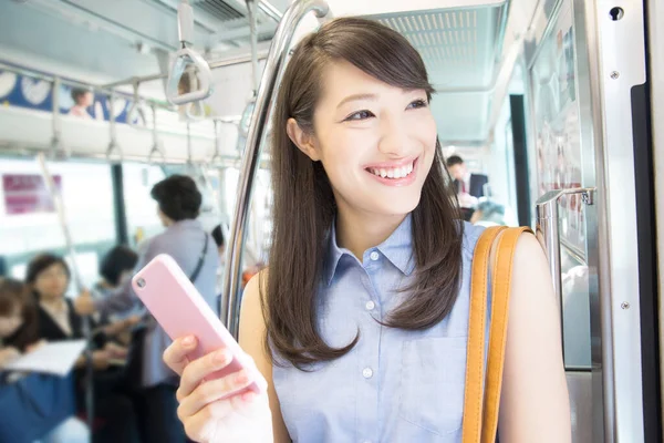 在地铁里用手机的亚洲女人 — 图库照片