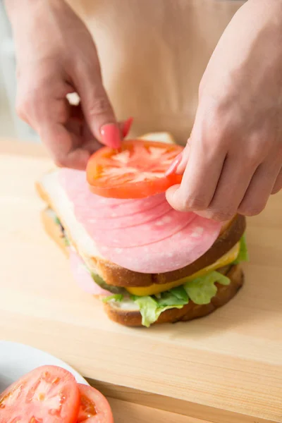 女人在厨房桌上做美味三明治的剪影 — 图库照片