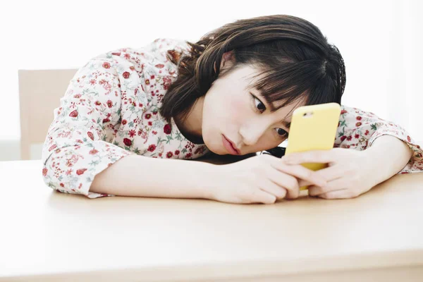 自宅でスマートフォンを使用して美しい若いアジアの女性 — ストック写真