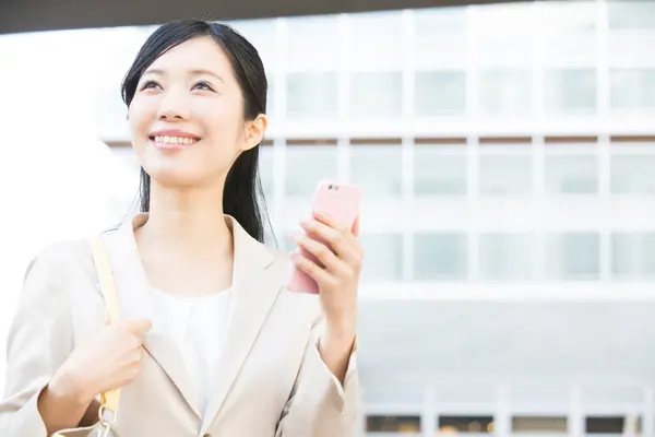 asian woman in business suit with mobile phone at outdoors