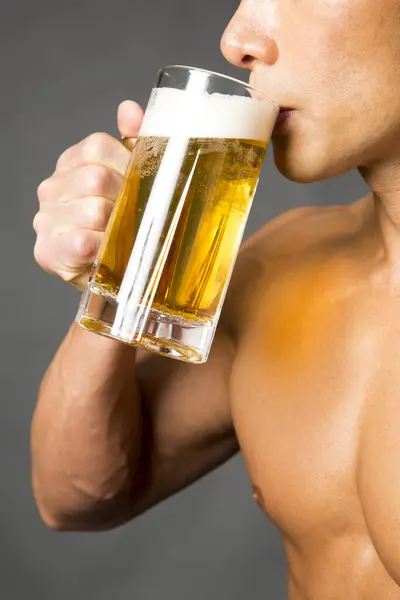 ビールのグラスを保持する筋肉体を持つ男の肖像画 — ストック写真