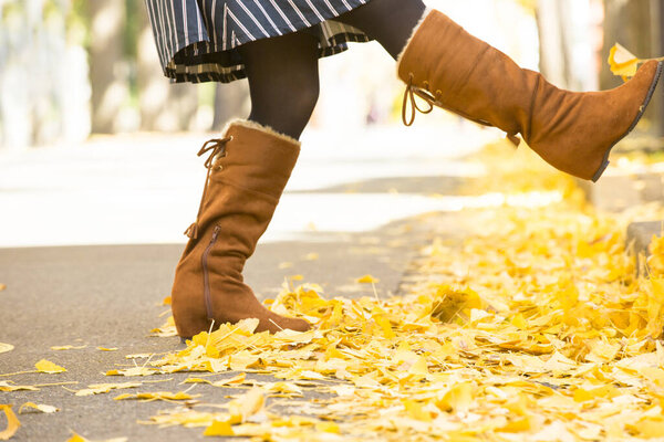 Девушка с желтыми листьями клена в осеннем парке.