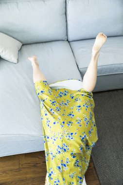 Kadın yerde yatıyor, kanepeden düşüyor.