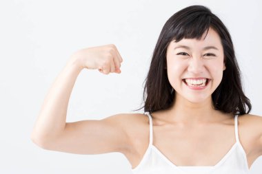 Mutlu Asyalı kadın pazılarını gösteriyor.