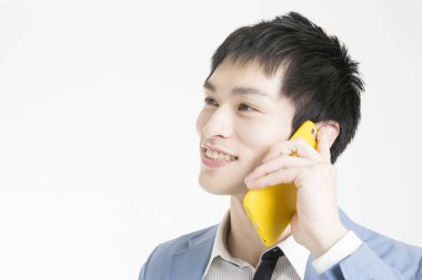 Beyaz arka planda izole edilmiş cep telefonu kullanan genç işadamı.