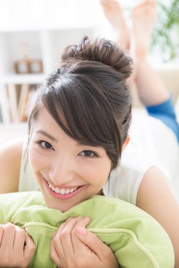 Kadın yastıkla evde dinleniyor. 