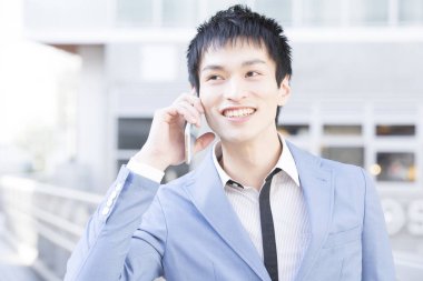 Cep telefonuyla konuşan Asyalı genç işadamının portresi