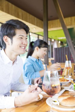 Genç ve mutlu bir çift restoranda yemek yiyor.