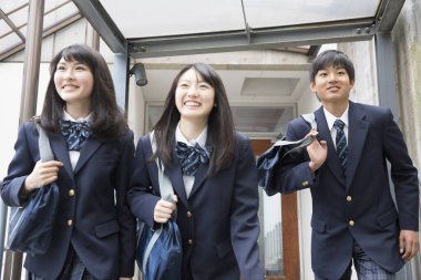 Okulda çantalı genç Japon öğrencilerin portresi.