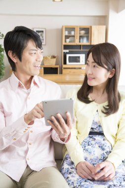 Evde tablet kullanan Asyalı çift. 