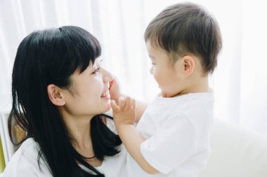 Genç bir kadın ve oğlu evde oynuyorlar. 