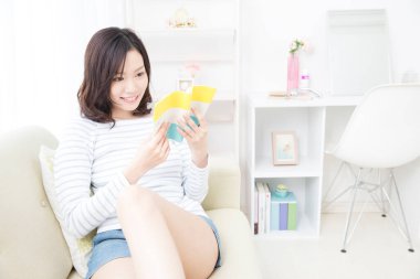 Evde kitap okuyan güzel Asyalı kadın