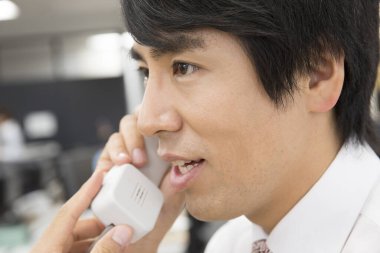 Ofiste telefonda konuşan Genç Asyalı adam 