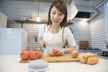 woman using wireless speaker and cooking