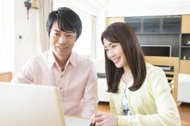 Genç Asyalı çift dizüstü bilgisayar kullanıyor.